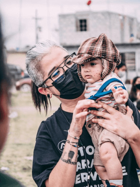 Woman holding a child during a community support activity