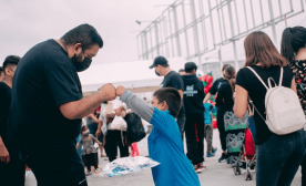 Man and child holding hands in a supportive gesture