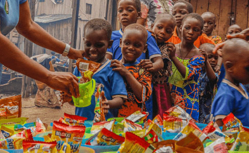 Person giving candies to poor children with kindnessv